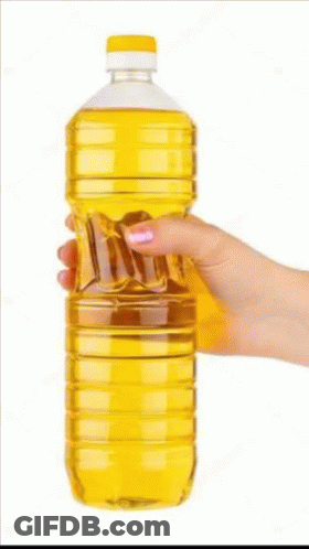 A Woman 'S Hand Is Holding A Bottle Of Oil . GIF