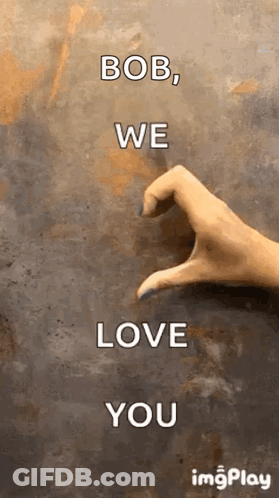A Woman 'S Hand Is Making A Heart Shape With Her Fingers On A Wall . GIF