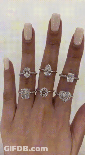 A Woman 'S Hand With Several Rings On It GIF