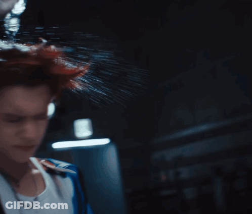 A Woman 'S Head Is Being Sprayed With Water In The Dark GIF