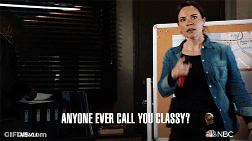 A Woman Says " Anyone Ever Call You Classy " While Standing In Front Of A Board GIF