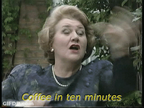 A Woman Says " Coffee In Ten Minutes " While Wearing A Pearl Necklace GIF