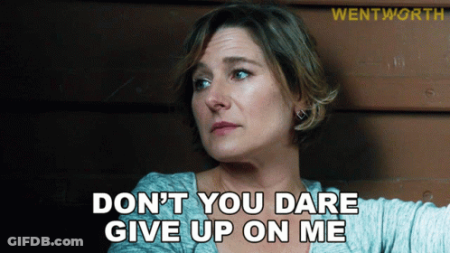 A Woman Says " Do N't You Dare Give Up On Me " In Front Of A Wooden Wall GIF