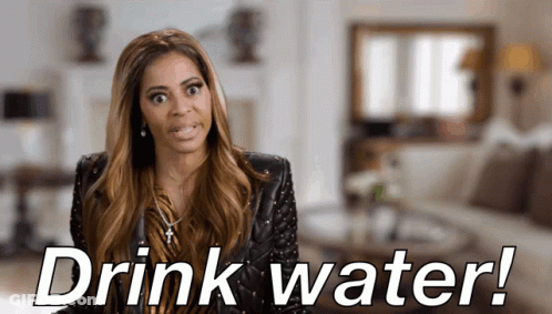 A Woman Says " Drink Water " In A Living Room GIF