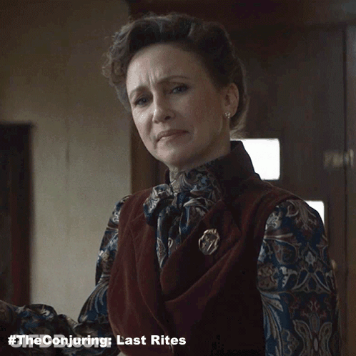 A Woman Says " Everything Okay " While Wearing A Vest And A Brooch GIF