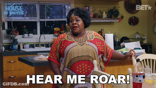 A Woman Says Hear Me Roar While Sitting At A Table GIF