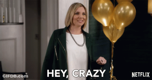 A Woman Says Hey Crazy In Front Of A Bunch Of Balloons GIF