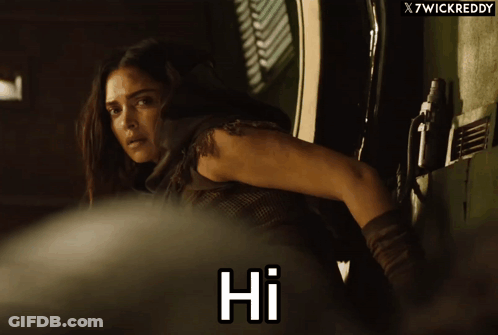 A Woman Says Hi In Front Of A X7wickreddy Banner GIF