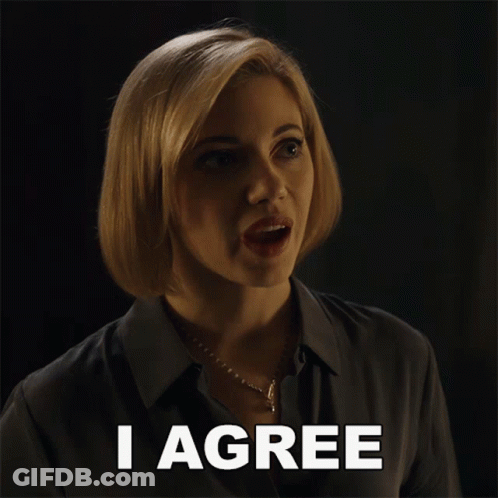 A Woman Says I Agree In Front Of A Dark Background GIF