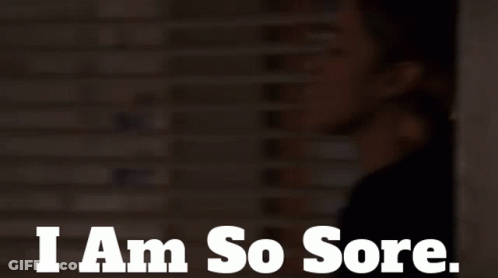 A Woman Says I Am So Sore In Front Of A Brick Wall GIF