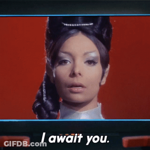 A Woman Says " I Await You " On A Red Background GIF