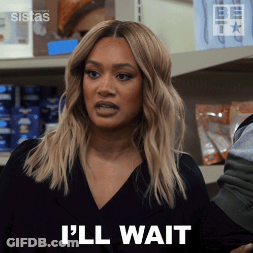 A Woman Says I 'Ll Wait In Front Of A Shelf GIF