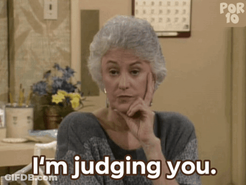 A Woman Says I 'M Judging You While Holding Her Hand To Her Chin GIF