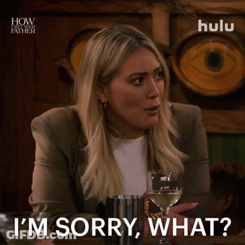 A Woman Says I 'M Sorry What While Holding A Glass Of Wine GIF