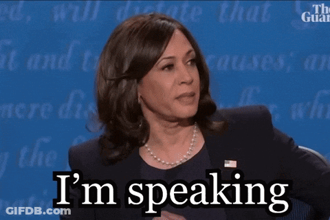 A Woman Says I 'M Speaking While Sitting At A Table GIF