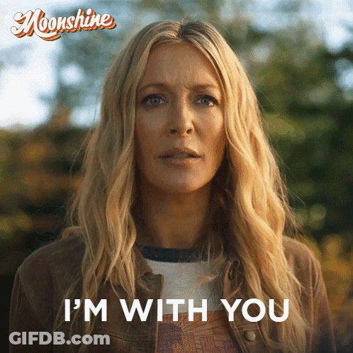 A Woman Says " I 'M With You " In Front Of A Poster For Moonshine GIF