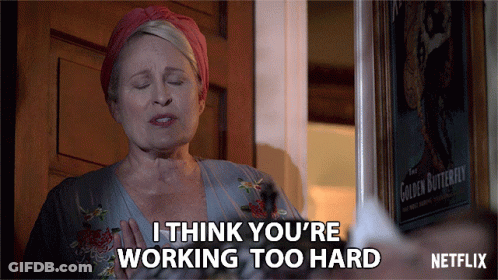 A Woman Says I Think You 'Re Working Too Hard In Front Of A Poster Of The Golden Butterfly GIF