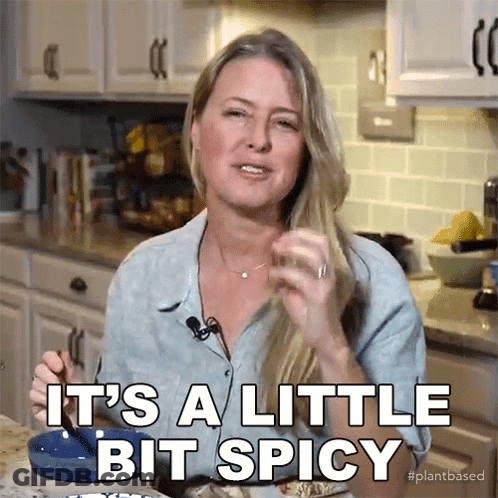 A Woman Says It 'S A Little Bit Spicy While Eating Food GIF