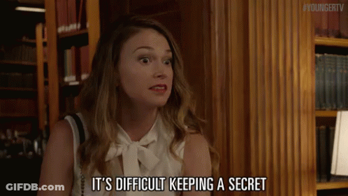 A Woman Says It 'S Difficult Keeping A Secret In Front Of A Bookshelf GIF