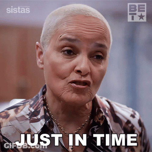 A Woman Says Just In Time While Wearing A Shirt And Necklace GIF