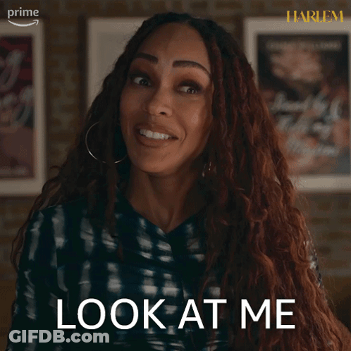 A Woman Says Look At Me In Front Of Some Framed Posters GIF