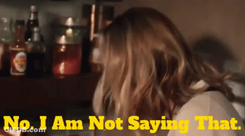 A Woman Says " No I Am Not Saying That " In Front Of A Shelf Full Of Bottles GIF