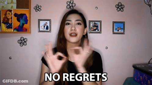 A Woman Says " No Regrets " In Front Of Pictures On A Wall GIF