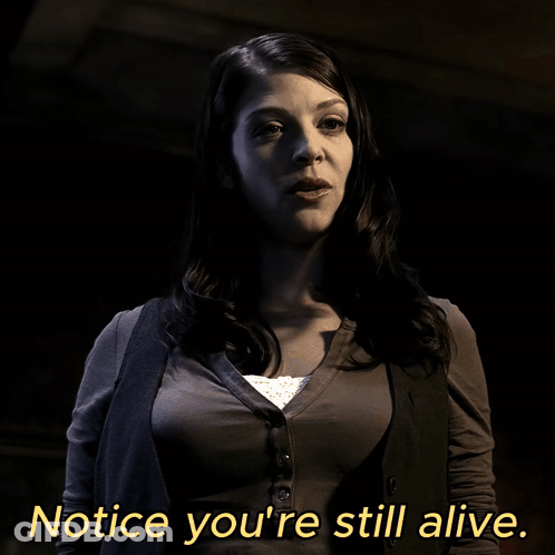 A Woman Says Notice You 'Re Still Alive In Yellow Letters GIF