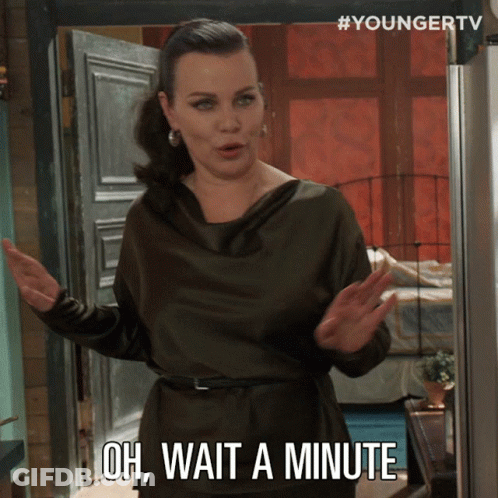 A Woman Says Oh Wait A Minute While Standing In Front Of A Door GIF