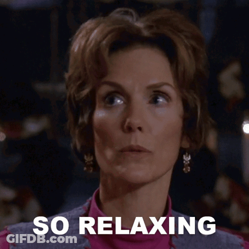 A Woman Says She Is So Relaxing In Front Of A Dark Background GIF