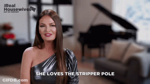 A Woman Says She Loves The Stripper Pole In Front Of A Piano And Couch GIF
