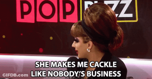 A Woman Says She Makes Me Cackle Like Nobody 'S Business In Front Of A Pop Buzz Sign GIF