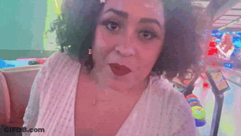 A Woman Says " U Heard Me " In Front Of A Pinball Machine GIF