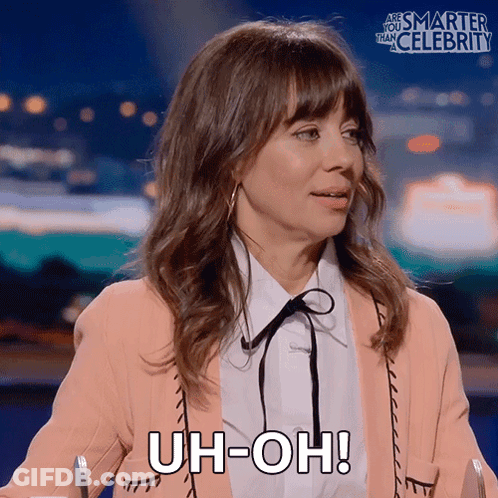 A Woman Says Uh-Oh While Sitting At A Table GIF