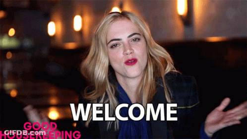 A Woman Says Welcome In Front Of A Good Housekeeping Ad GIF