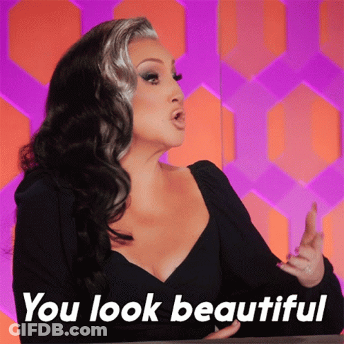 A Woman Says " You Look Beautiful " In Front Of A Purple And Orange Background GIF