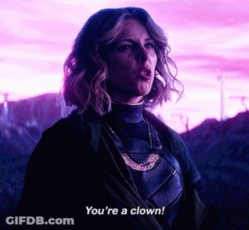 A Woman Says " You 'Re A Clown " While Standing In A Field GIF