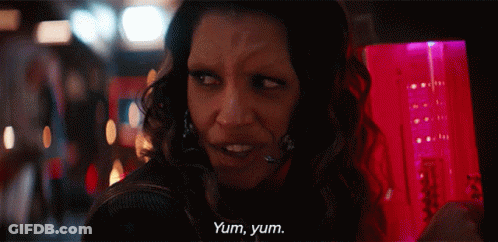 A Woman Says Yum Yum In Front Of A Pink Container GIF