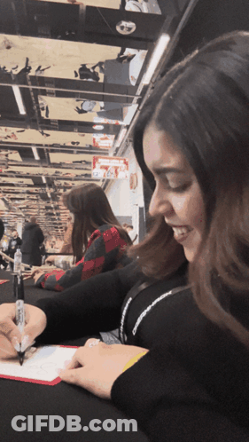 A Woman Signing A Piece Of Paper With A Marker GIF