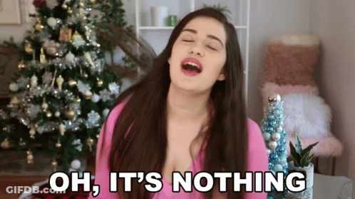 A Woman Singing In Front Of A Christmas Tree With The Words Oh It 'S Nothing Below Her GIF