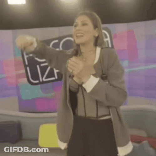 A Woman Singing Into A Microphone In Front Of A Fofo Sign GIF