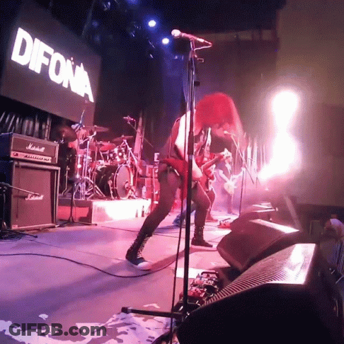 A Woman Singing Into A Microphone In Front Of A Sign That Says " Difona " GIF