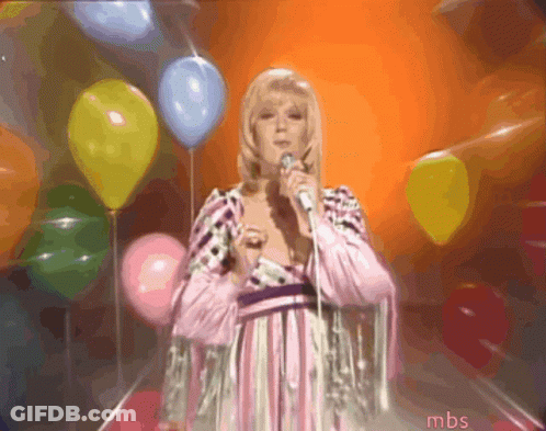A Woman Singing Into A Microphone In Front Of Balloons With Mbs Written On The Bottom GIF
