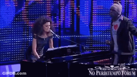 A Woman Singing Into A Microphone Next To A Man Playing A Piano With The Words No Perditempo Forum Written On The Bottom GIF