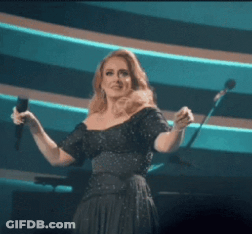 A Woman Singing Into A Microphone On A Stage GIF