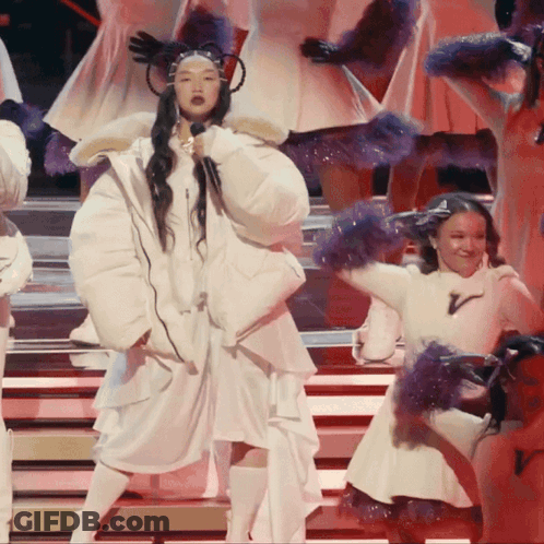 A Woman Singing Into A Microphone On Stage GIF