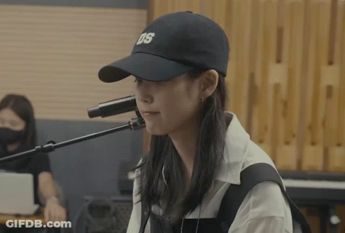 A Woman Singing Into A Microphone Wearing A Hat That Says Ds GIF