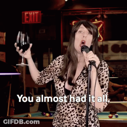 A Woman Singing Into A Microphone While Holding A Glass Of Wine And The Words " You Almost Had It All " GIF