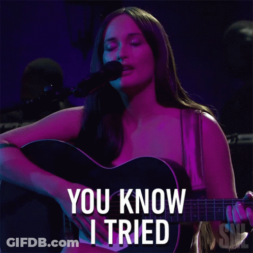 A Woman Singing Into A Microphone While Holding A Guitar With The Words You Know I Tried Written Below Her GIF