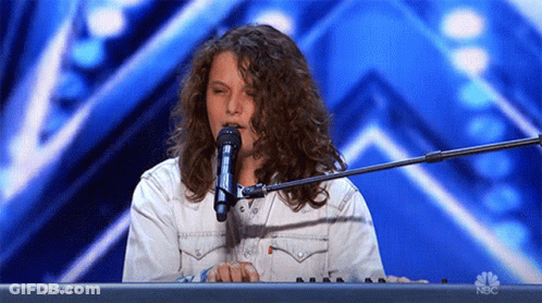A Woman Singing Into A Microphone While Playing A Keyboard With Nbc Written On The Bottom GIF